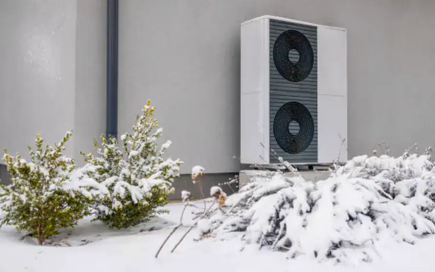 heat pump cop in cold weather, heat pump in the snow next to a wall
