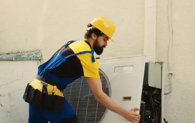 heat pump installer in the uk installing one on a wall